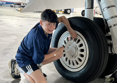 Kid that participated in Bring Your Kid To Work Day pictured with aircraft wheel.
