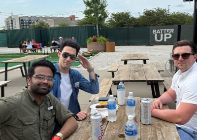 Airshare employees seated at a picnic table at the Monarchs game.