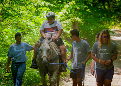 Airshare employee Michael Regan leading a camper riding a horse.
