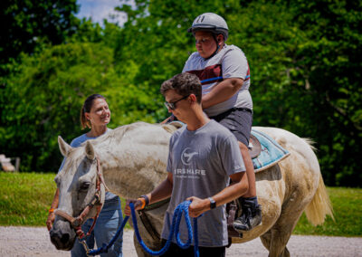 Airshare employee Michael Regan leading a camper riding a horse.